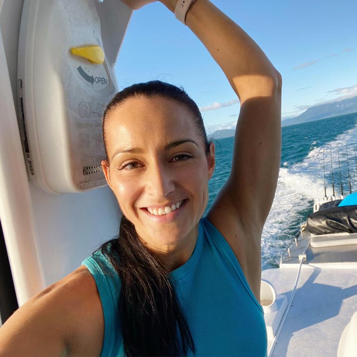 Woman smiling standing on boat at sea